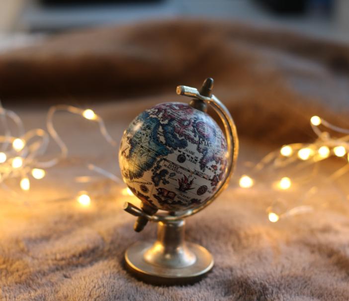 earth globe surrounded by christmas lights